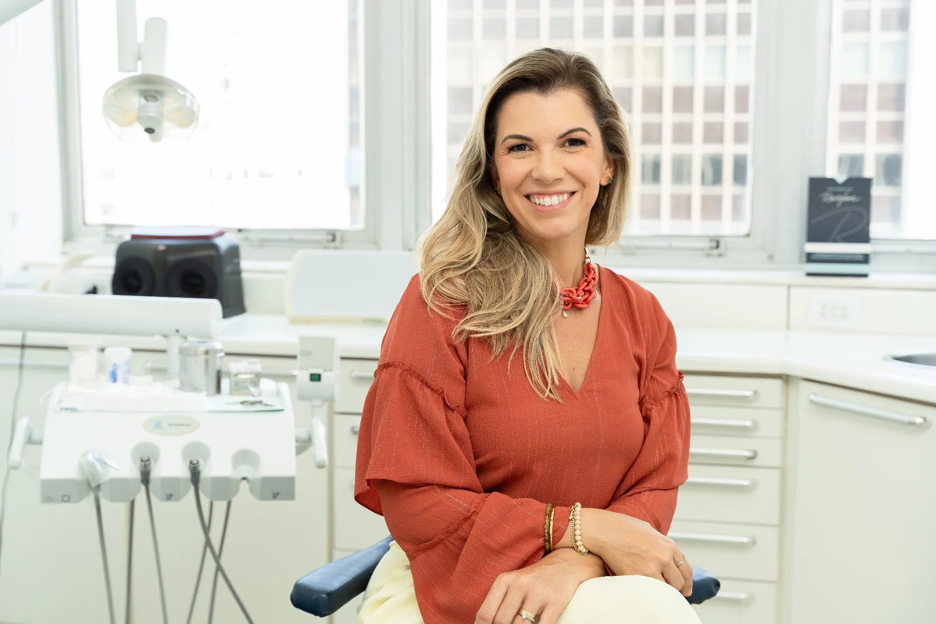 Dra. Carla Christoph, dentista em Ipanema, sorrindo em seu consultório de odontologia estética.